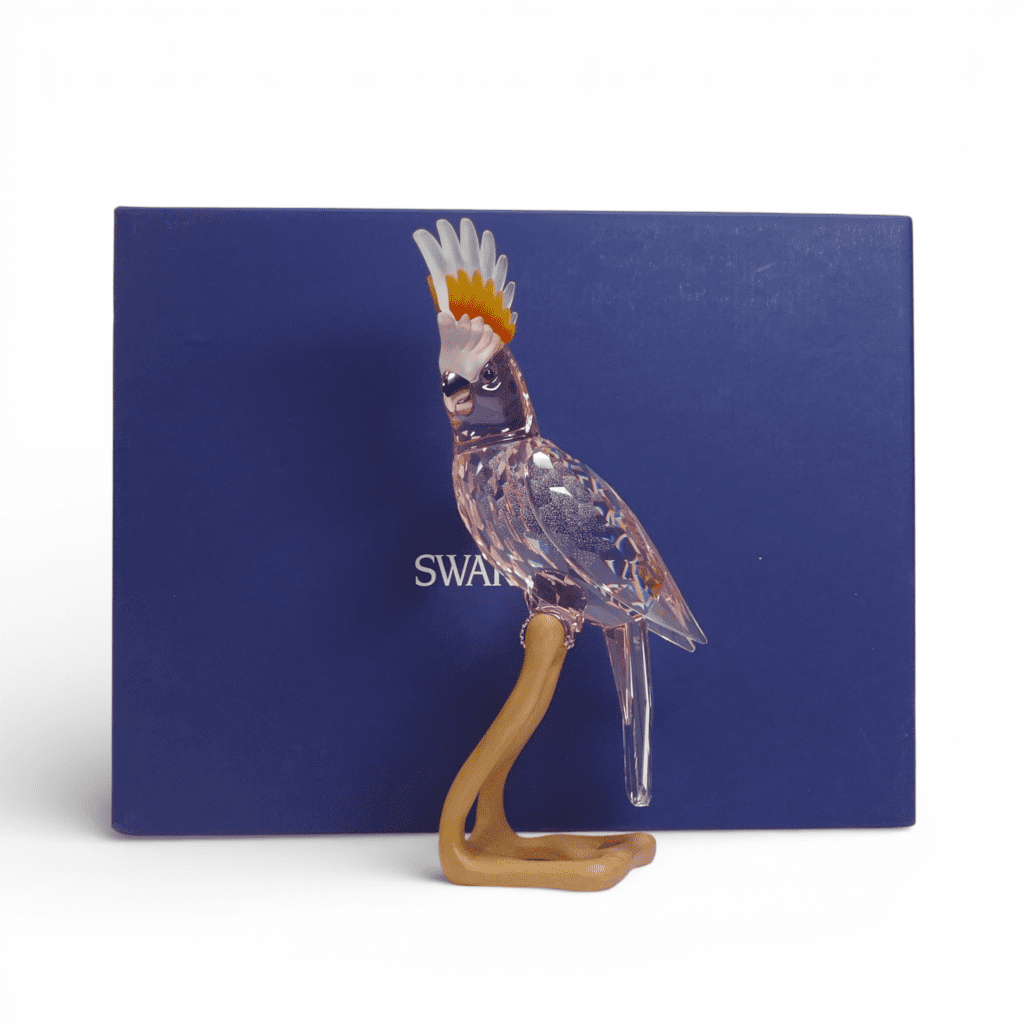 Swarovski Crystal Paradise Cockatoo Red figure mounted on wooden perch, designed by Roland Schuster, with original box (718565) retired 2010. (H: 24.5cm)